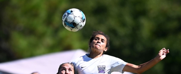 Knights women's soccer player headbutting a ball during a game.